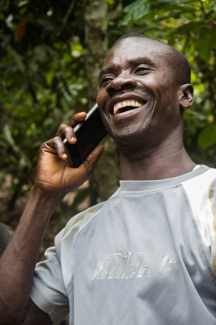 Man laughing while on a phone call outdoors